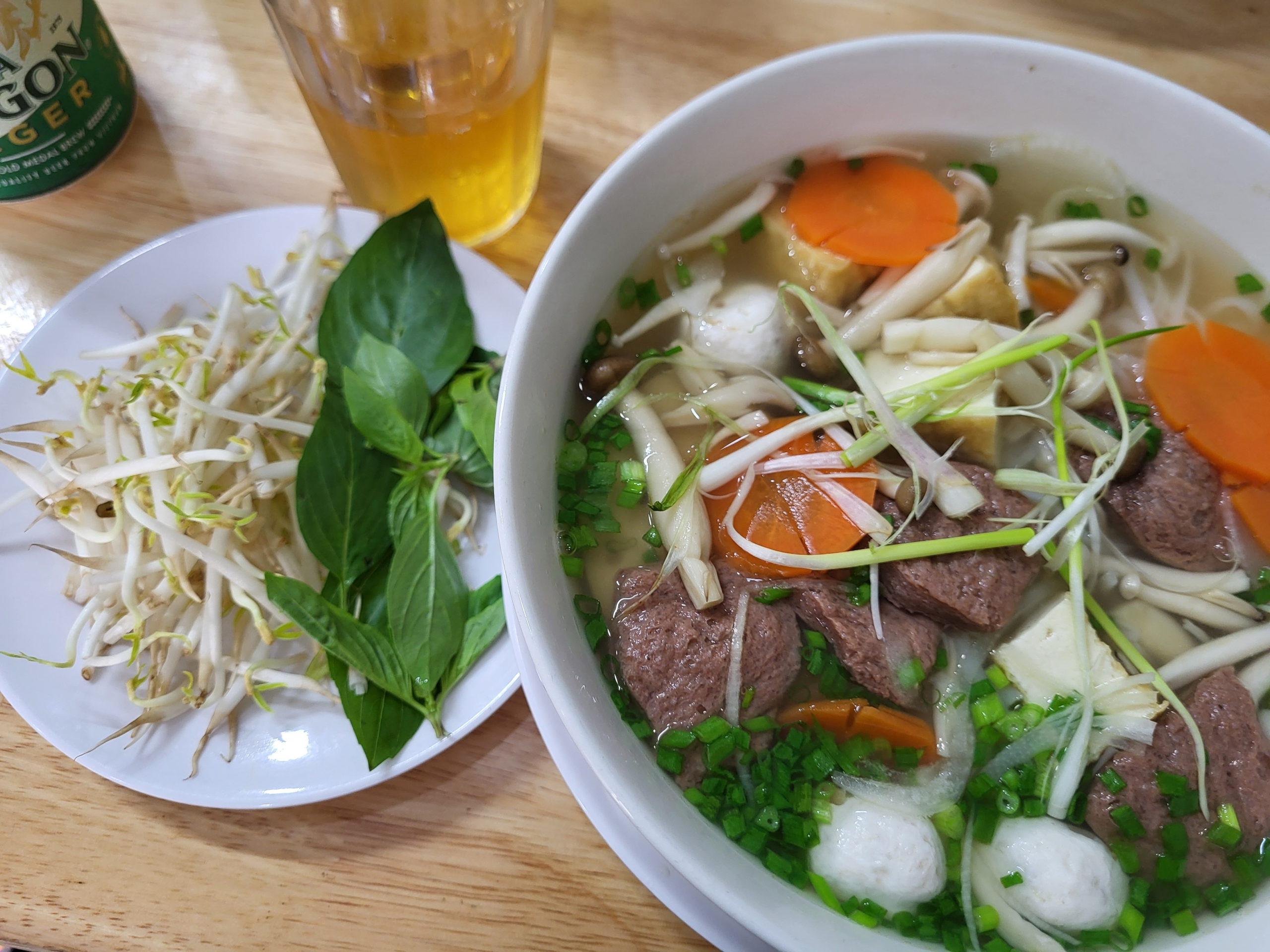A steaming bowl of traditional Vietnamese pho, filled with rice noodles, tender beef slices, fresh herbs, and aromatic broth — comfort in every spoonful.