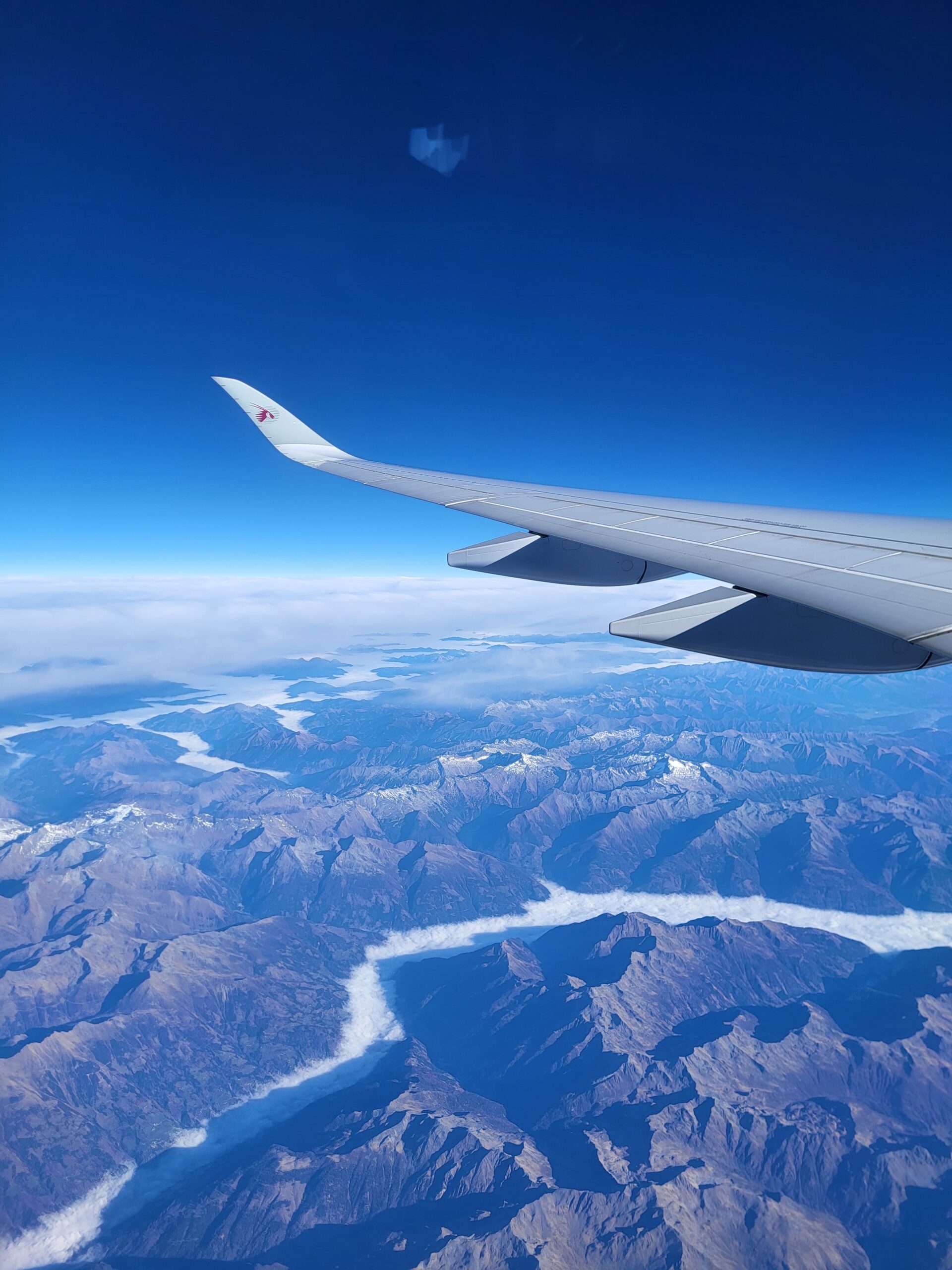 A breathtaking view of a plane soaring over majestic mountains, capturing adventure and scenic beauty from above
