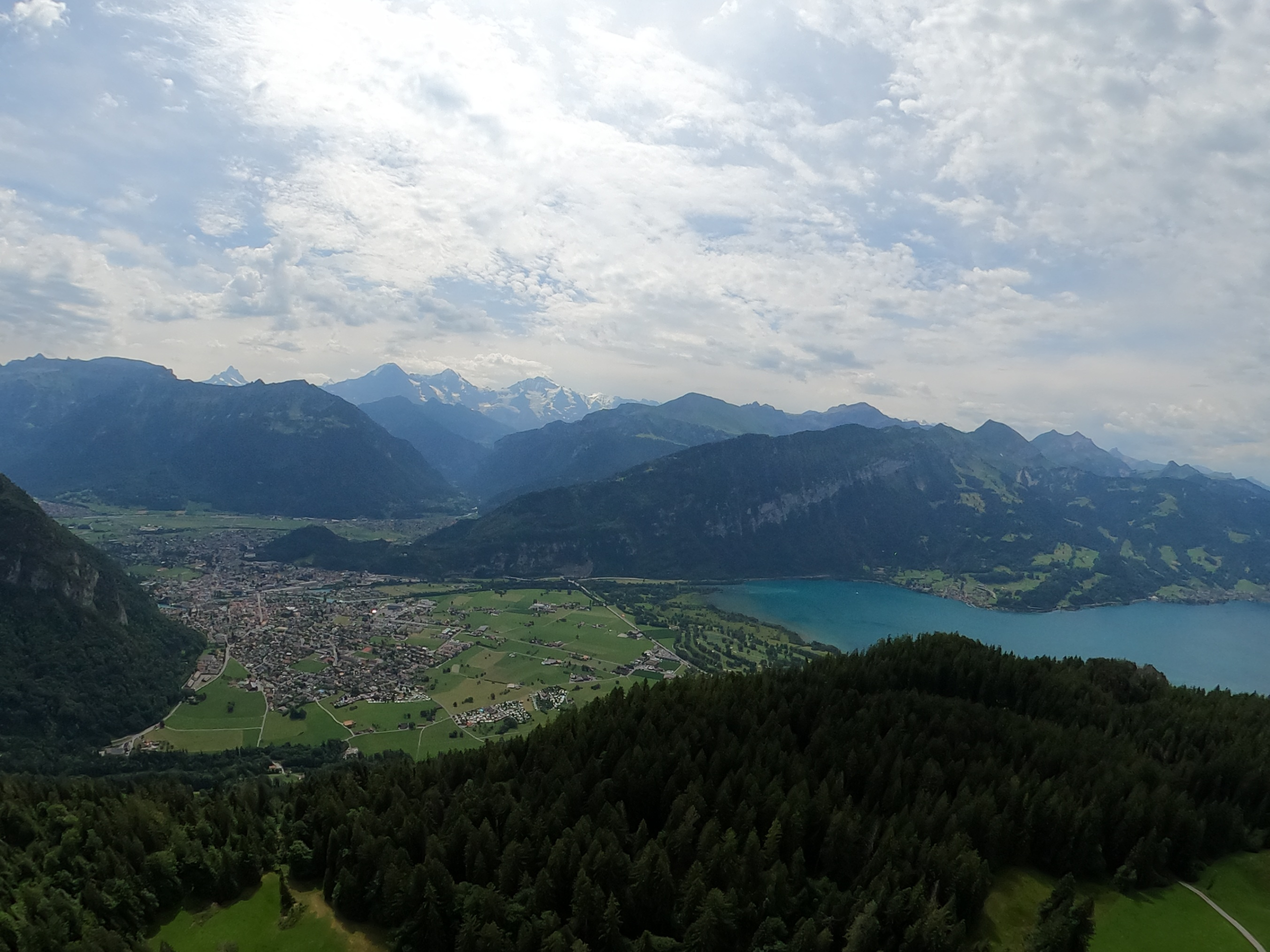 Paragliding over Interlaken with panoramic views of the Swiss Alps and turquoise lakes below