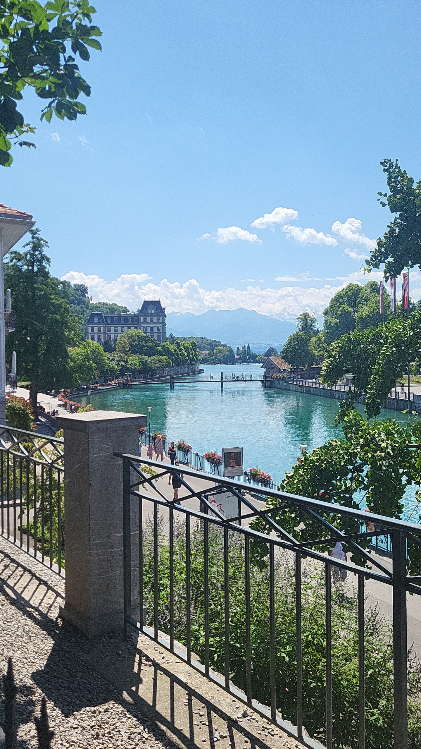 Charming springtime in Thun, Switzerland, featuring riverside blooms, historic buildings, and majestic Alpine scenery