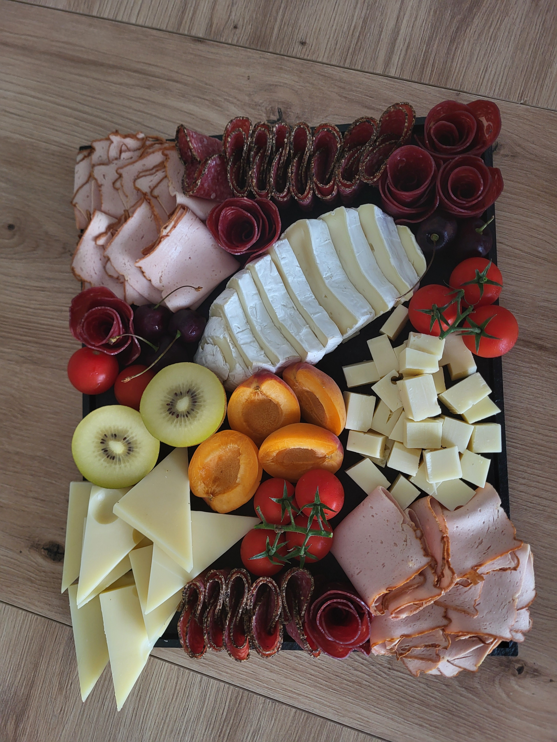 A Swiss charcuterie board featuring cured meats, cheeses, bread, nuts, and fresh fruit.